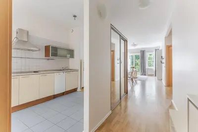 a kitchen with white cabinets and a dining room at Barbacan by Monto in Vilnius