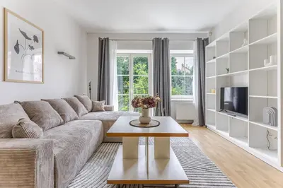 a living room with a couch and a table at Barbacan by Monto in Vilnius