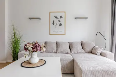 a living room with a couch and a table with flowers at Barbacan by Monto in Vilnius