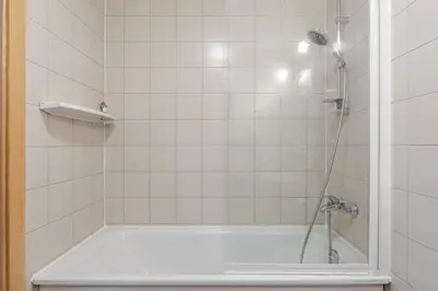 a bathroom with a bath tub with a shower at Barbacan by Monto in Vilnius