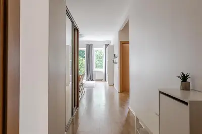 a hallway of a house with white walls and wooden floors at Barbacan by Monto in Vilnius