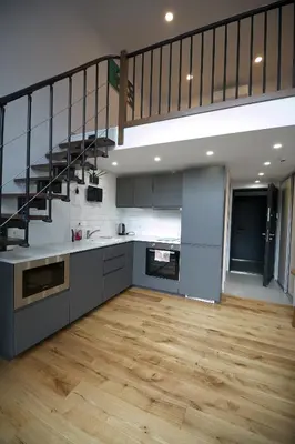 a large kitchen with a staircase in a loft at KgB - 32, Stylish City Apartment - 10 mins walk to Old Town in Vilnius