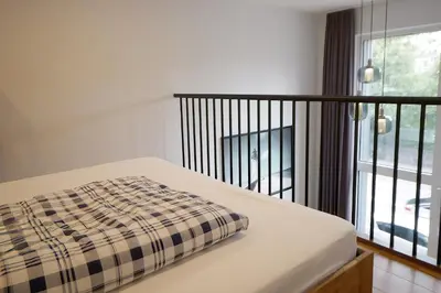 a bed with a plaid blanket on it next to a window at KgB - 32, Stylish City Apartment - 10 mins walk to Old Town in Vilnius