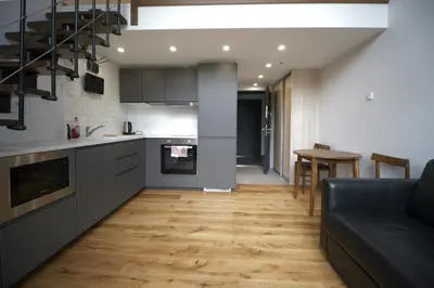 a kitchen and living room with a couch and a table at KgB - 32, Stylish City Apartment - 10 mins walk to Old Town in Vilnius