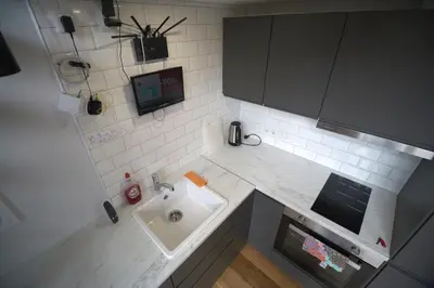 a small kitchen with a sink and a microwave at KgB - 32, Stylish City Apartment - 10 mins walk to Old Town in Vilnius