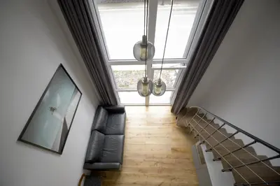 a room with a staircase with chairs and a window at KgB - 32, Stylish City Apartment - 10 mins walk to Old Town in Vilnius