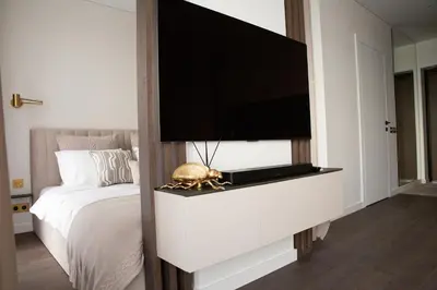 a bedroom with a flat screen tv on a wall at Brand new luxurious apartment in Vilnius center in Vilnius