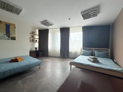 a bedroom with two beds and a large window at Cozy Seliu 29 in Vilnius