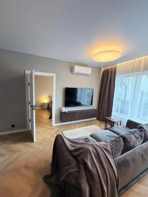 a living room with a couch and a flat screen tv at Two bedroom LUXURIOUS Spacios Apartment in Vilnius