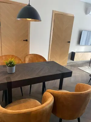 a dining room with a wooden table and chairs at Two bedroom LUXURIOUS Spacios Apartment in Vilnius