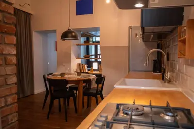 a kitchen with a table with chairs and a stove at Steponas Old Town Studio in Vilnius