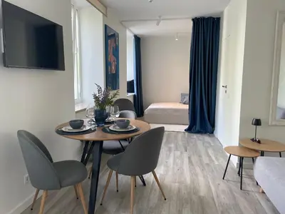 a living room with a table and chairs and a bedroom at Apartment Parko in Molėtai