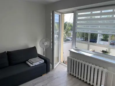 a living room with a couch and a window at VILNIUS apartment with balcony in Vilnius
