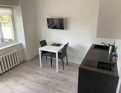 a small kitchen with a white table and chairs at VILNIUS apartment with balcony in Vilnius