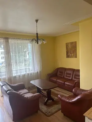 a living room with leather furniture and a table at Kaunas Vibes Apartament in Kaunas