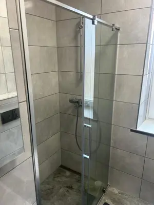 a shower stall with a glass shower door at Kaunas Vibes Apartament in Kaunas