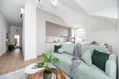 a living room with a blue couch and a kitchen at Top Floor, Spacious Apartment w-Balcony & Garage I Cohost in Vilnius