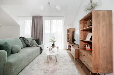 a living room with a green couch and a table at Top Floor, Spacious Apartment w-Balcony & Garage I Cohost in Vilnius