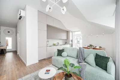 a living room with a green couch and a kitchen at Top Floor, Spacious Apartment w-Balcony & Garage I Cohost in Vilnius