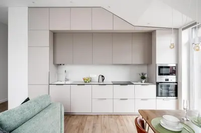 a kitchen with white cabinets and a blue couch at Top Floor, Spacious Apartment w-Balcony & Garage I Cohost in Vilnius