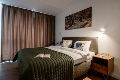 a bedroom with a bed with a book on it at Top Floor, Spacious Apartment w-Balcony & Garage I Cohost in Vilnius