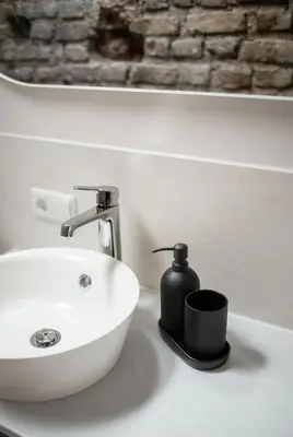 a bathroom sink with a soap dispenser on it at Castle Street Modern Apartments I cohost in Vilnius