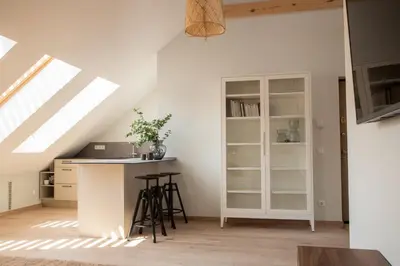 an attic kitchen with a counter and a book shelf at Castle Street Modern Apartments I cohost in Vilnius