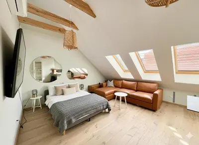 a bedroom with a bed and a couch at Castle Street Modern Apartments I cohost in Vilnius