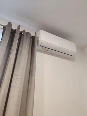 a ceiling mounted air conditioner in a room with curtains at UrbanHome Rokiškis in Rokiškis