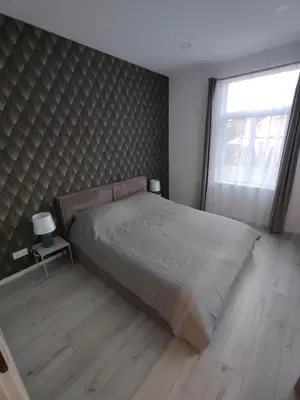 a bedroom with a large bed and a window at UrbanHome Rokiškis in Rokiškis