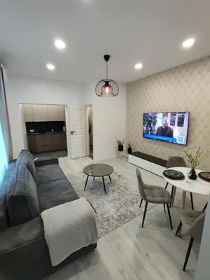a living room with a couch and a table at UrbanHome Rokiškis in Rokiškis