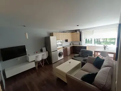 a living room with a couch and a kitchen at Julia's Apartment