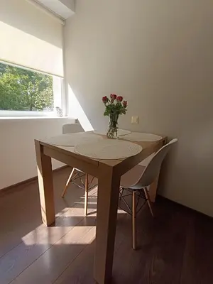 a dining room table with a vase of flowers on it at Julia's Apartment