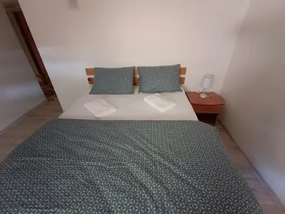 a bedroom with a large bed with green sheets and pillows at Julia's Apartment