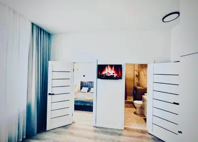 a bedroom with a bed and a fire in the wall at M&M Apartment III SELF CHECK-IN in Panevėžys