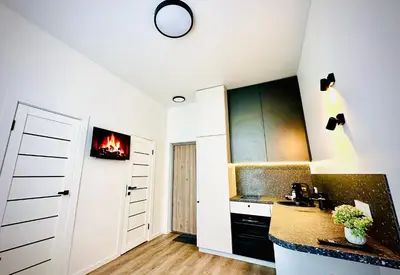 a kitchen with white cabinets and a stove at M&M Apartment III SELF CHECK-IN in Panevėžys