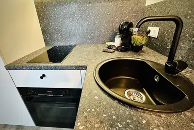 a kitchen counter with a sink and a phone at M&M Apartment III SELF CHECK-IN in Panevėžys