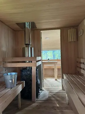 a inside of a cabin with benches and a stove at Glamp Juodis in Ubiškės
