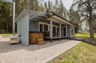 a tiny house with a roof on gravel at Vakaris in Pabradė