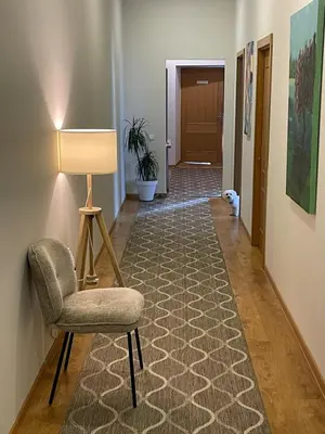 a hallway with a chair and a lamp at Studija Mona in Vilnius