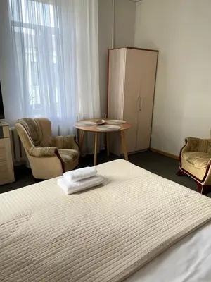a bedroom with a bed and a table and chairs at Studija Mona in Vilnius