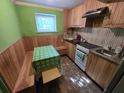 a small kitchen with a table and a sink at Pas Povilą in Jurbarkas