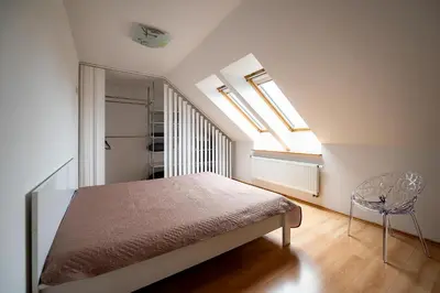 a bedroom with a bed and two skylights at Spacious & Private Stay in Garliava 120kv in Garliava