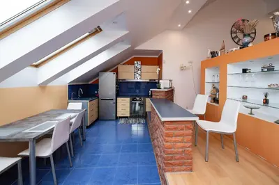 a kitchen with blue tile floors and a long counter with white chairs at Spacious & Private Stay in Garliava 120kv in Garliava