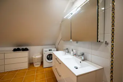 a bathroom with a sink and a washing machine at Spacious & Private Stay in Garliava 120kv in Garliava
