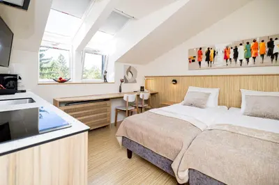 a bedroom with a bed and a desk and a tv at Embassy Studio 303 in Vilnius