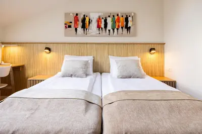 two beds in a bedroom with a painting on the wall at Embassy Studio 303 in Vilnius