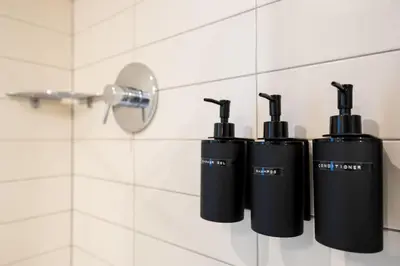 a group of three black bottles on a wall in a bathroom at Embassy Studio 303 in Vilnius