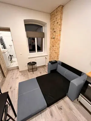 a living room with a couch and a table at Tiny Brick Loft in Vilnius