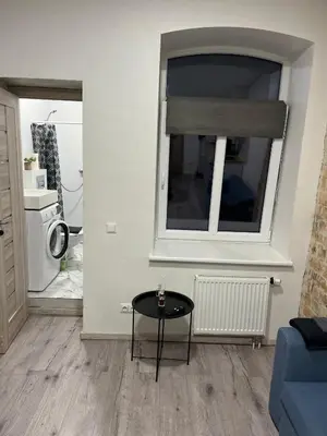 a living room with a table and a window at Tiny Brick Loft in Vilnius